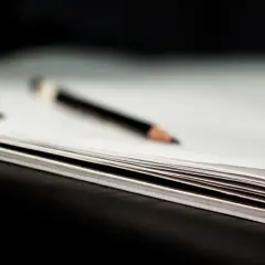 Otwarta książka z ołówkiem i gumką do ścierania.